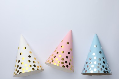 Beautiful party hats on light background, top view. Space for text