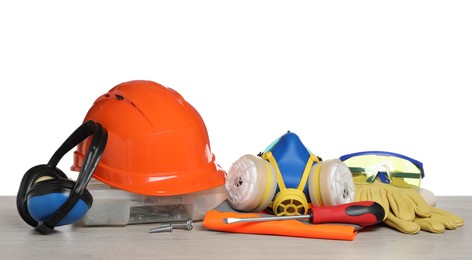 Set with safety equipment and tools on wooden table against white background