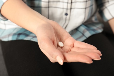 Photo of Woman holding pill in hand, closeup view
