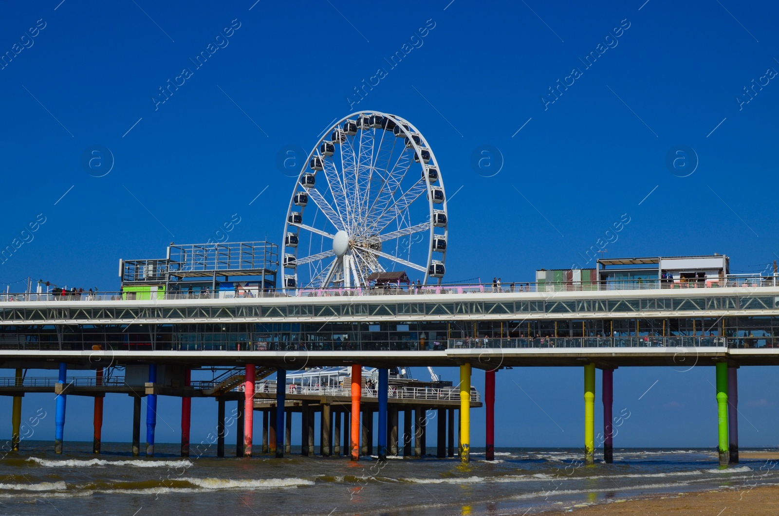 Photo of Beautiful view of beach and pier with Ferris wheel