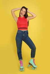 Photo of Full length portrait of young woman with roller skates on color background