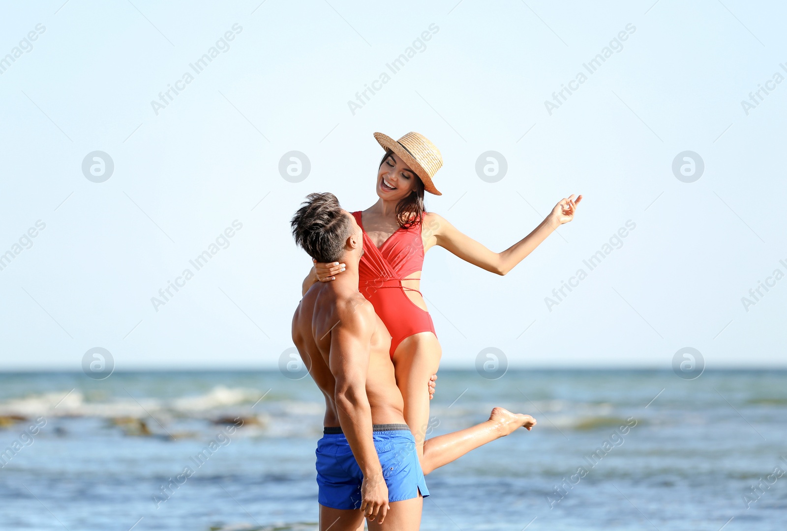 Photo of Happy young couple having fun at beach on sunny day