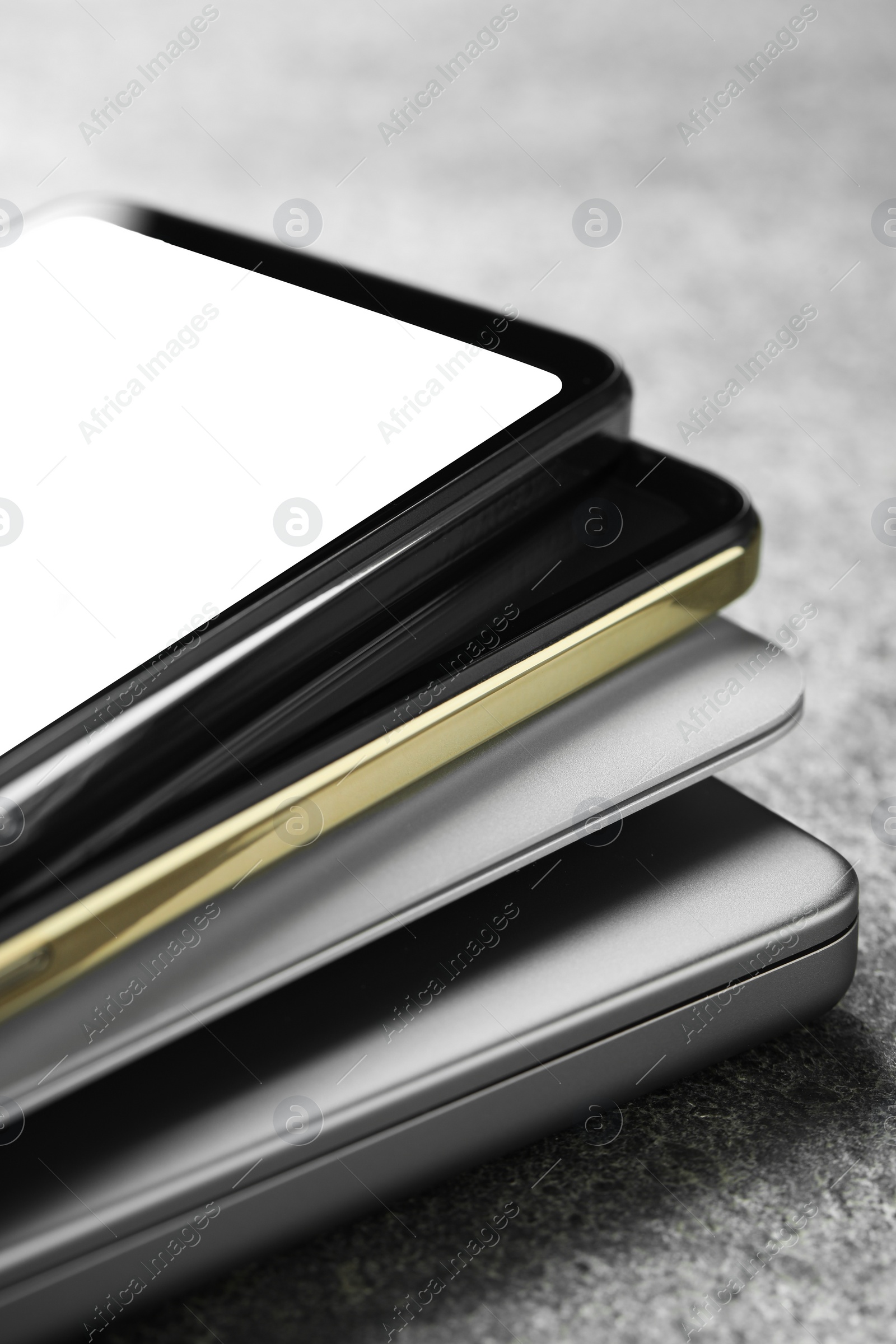 Photo of Stack of electronic devices on grey table, closeup