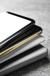 Photo of Stack of electronic devices on grey table, closeup