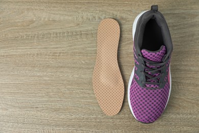 Orthopedic insole near shoe on floor, flat lay. Space for text
