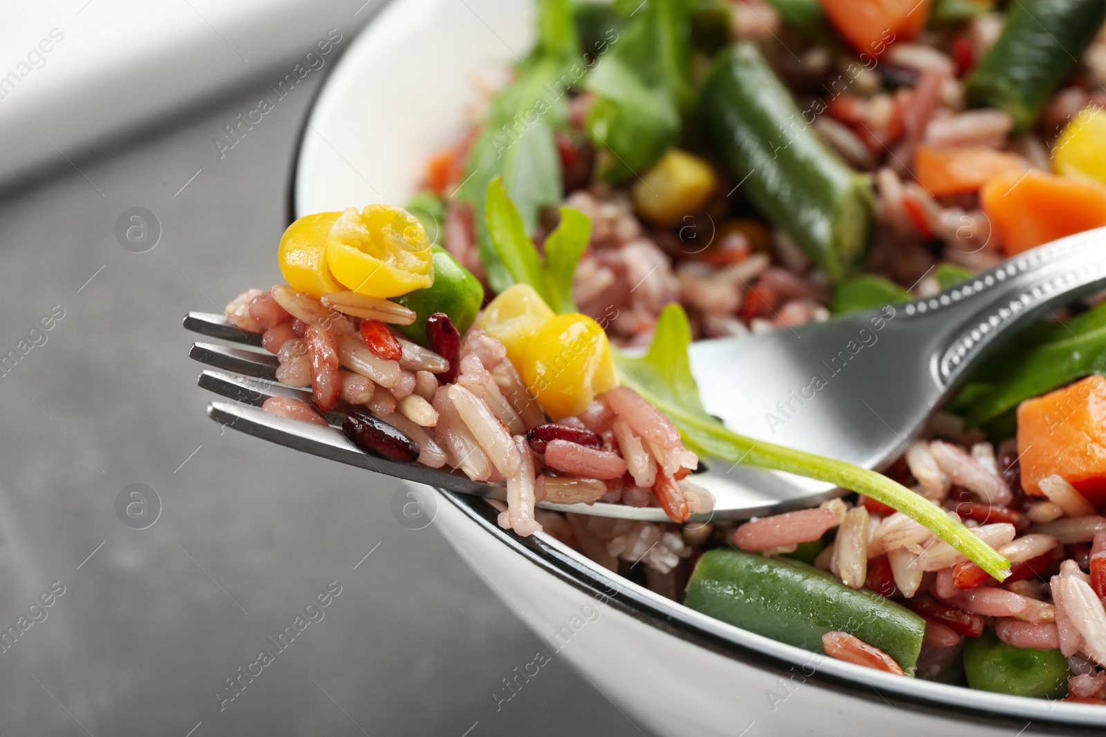 Photo of Tasty brown rice with vegetables, closeup view