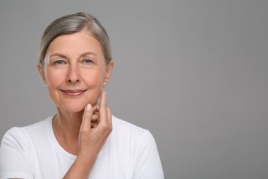 Photo of Portrait of senior woman with aging skin on grey background, space for text. Rejuvenation treatment