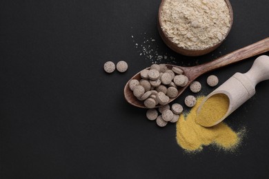 Photo of Different types of brewer`s yeast on black background, flat lay. Space for text