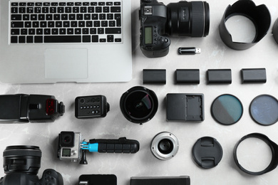 Photo of Flat lay composition with equipment for professional photographer on grey marble table