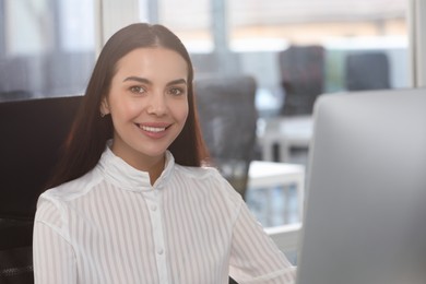Photo of Happy woman using modern computer in office
