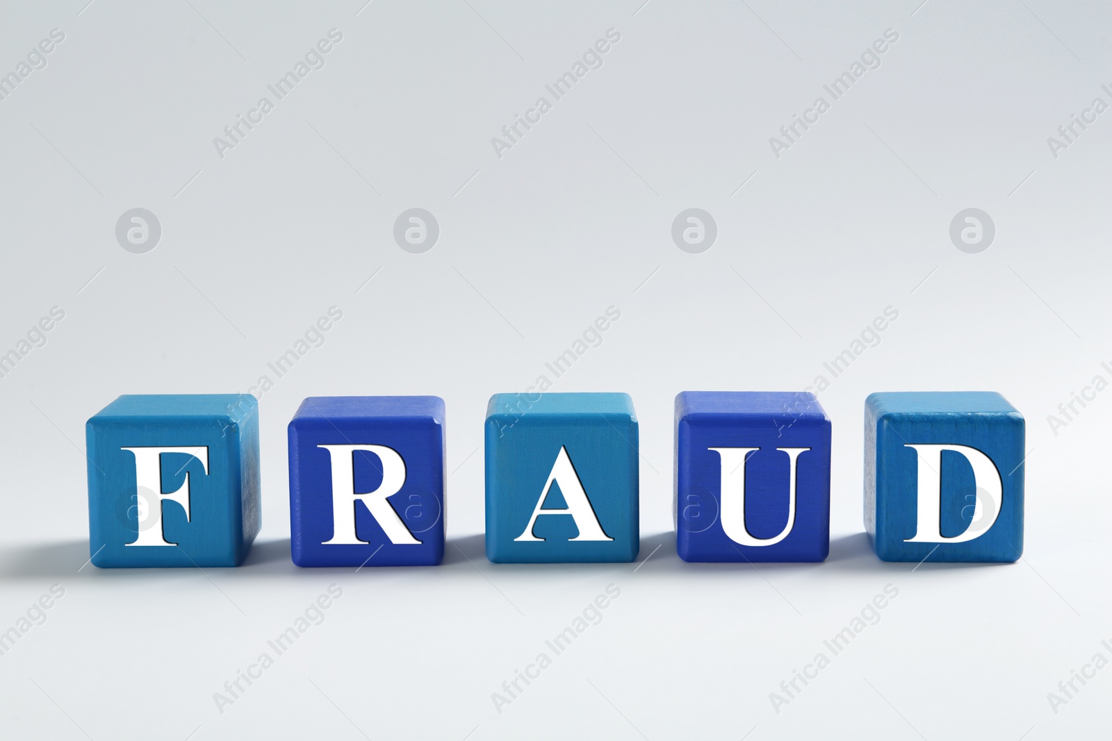 Photo of Word Fraud of wooden cubes with letters on light background. Space for text