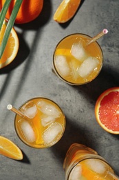 Delicious orange soda water on grey table, flat lay