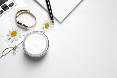 Photo of Flat lay composition with jar of hand cream and chamomiles on white table, space for text