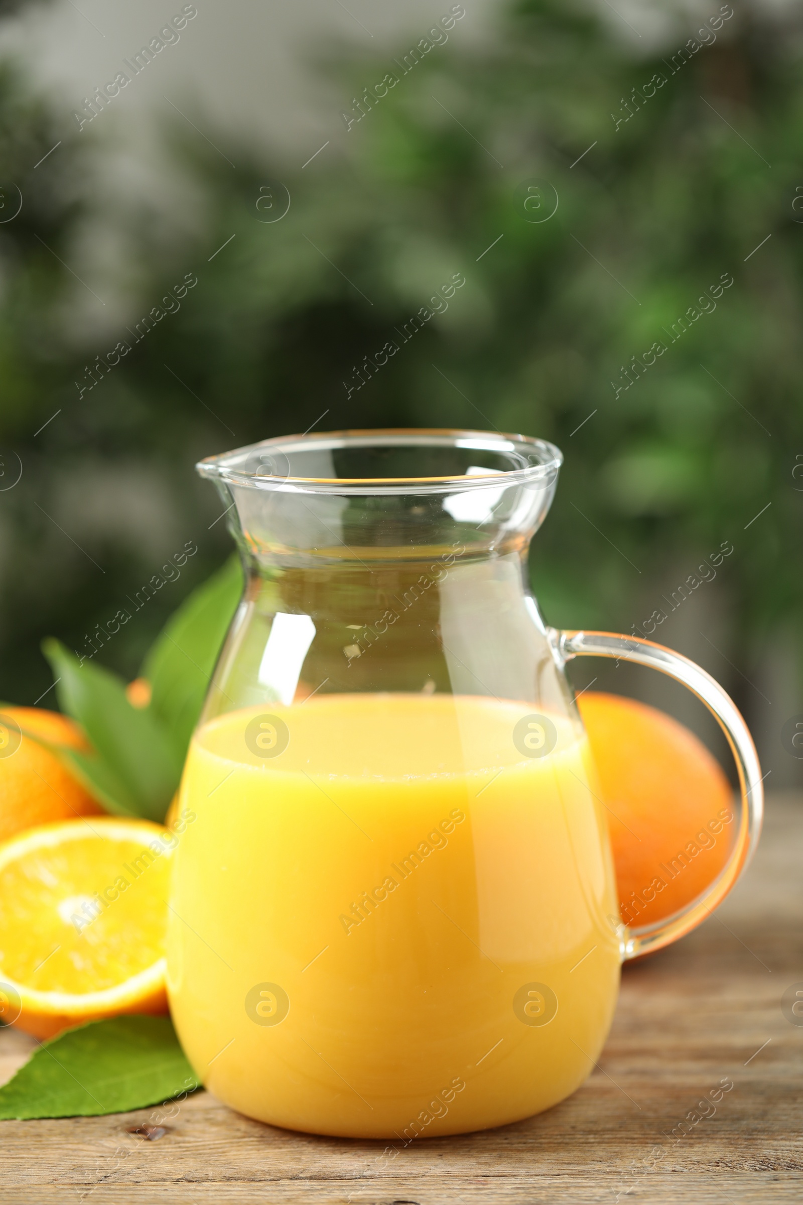 Photo of Jug of orange juice and fresh fruits on wooden table