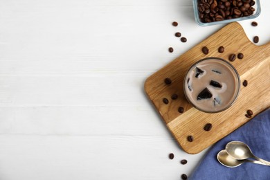 Photo of Glass of milk with grass jelly and coffee beans on white wooden table, flat lay. Space for text