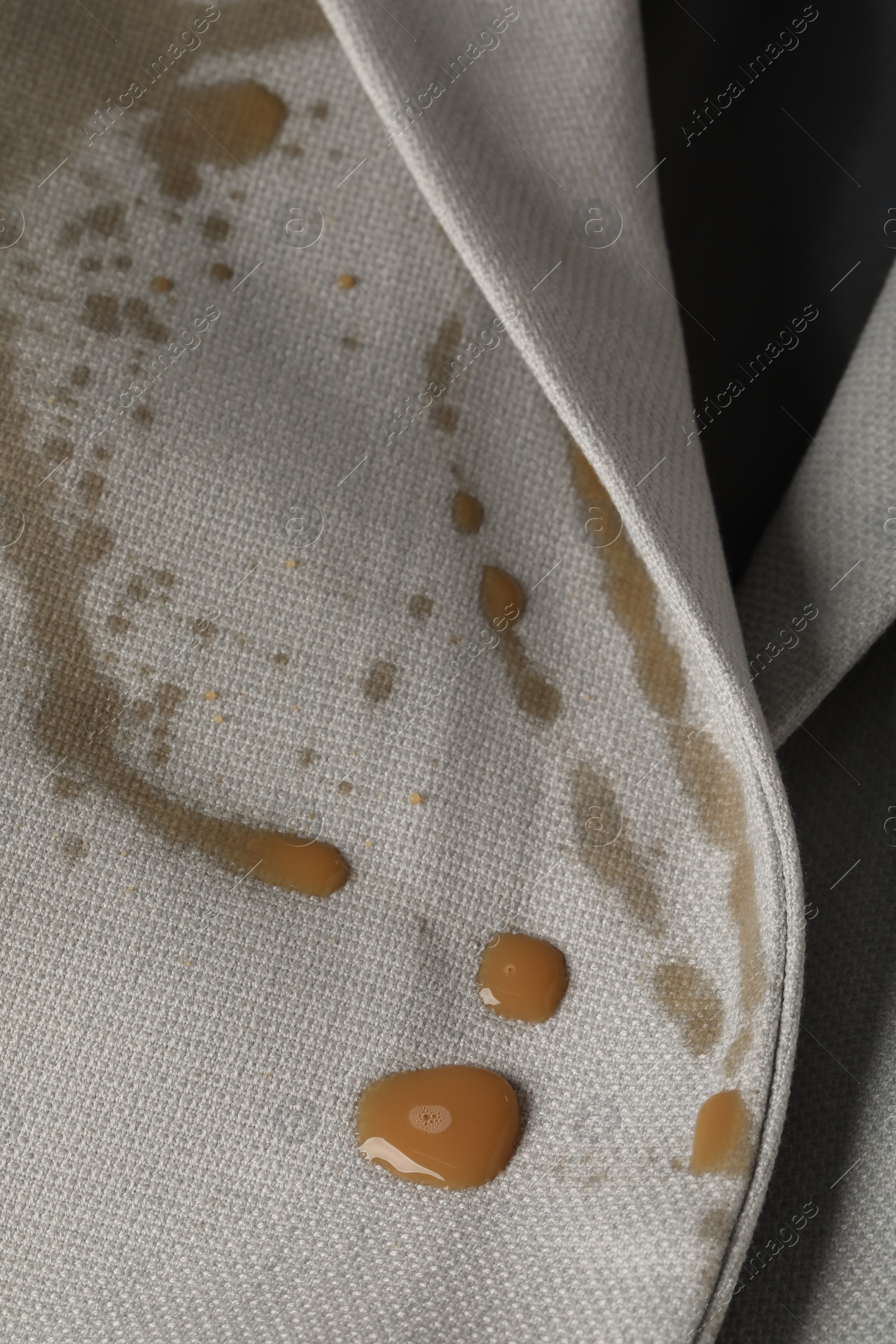 Photo of Dirty jacket with stain of coffee as background, closeup