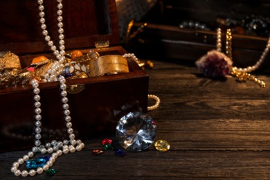 Photo of Chest with treasures on wooden floor, space for text