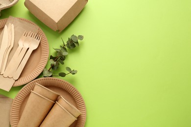 Flat lay composition with eco friendly products on light green background, space for text