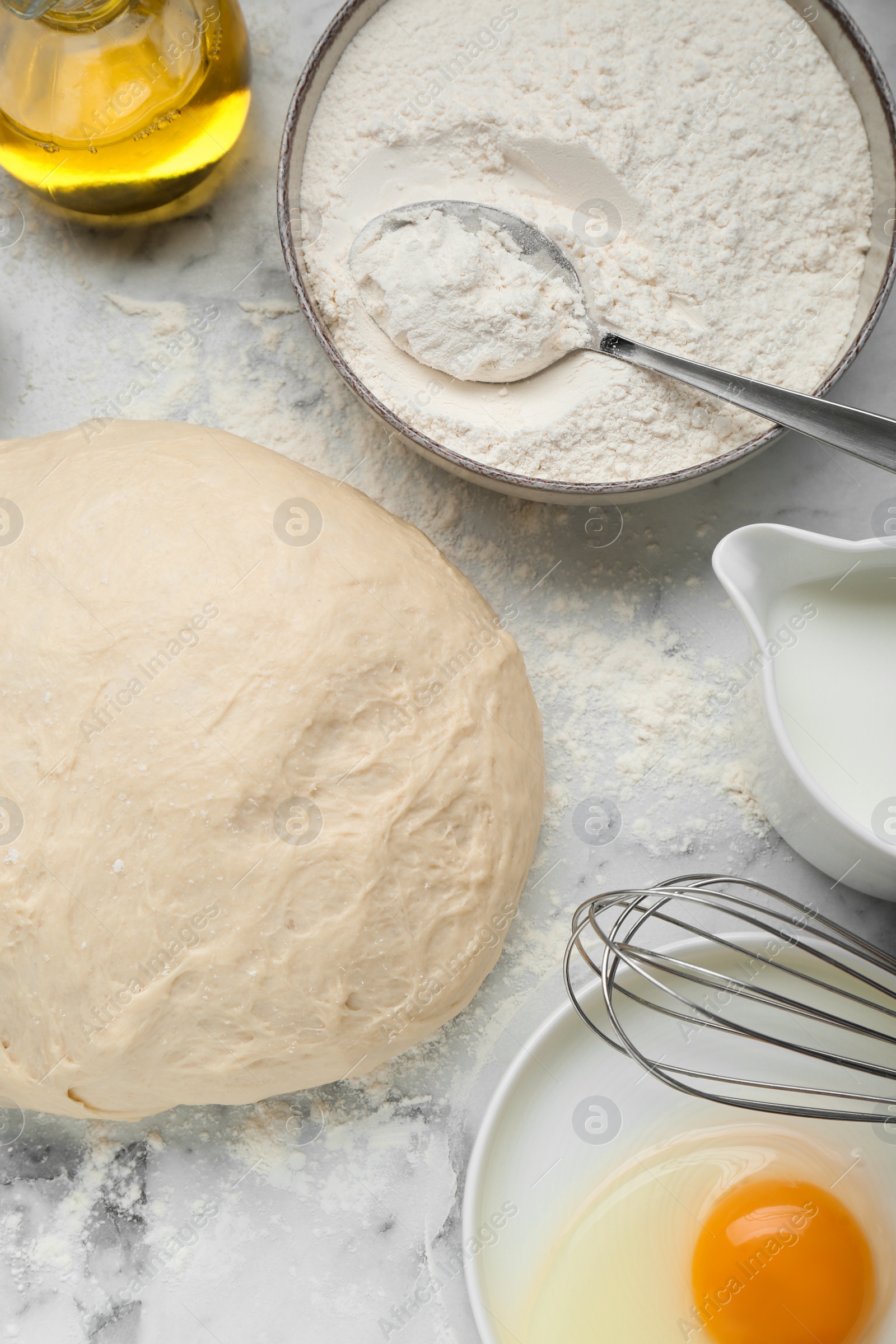 Photo of Fresh yeast dough and ingredients on white marble table, flat lay