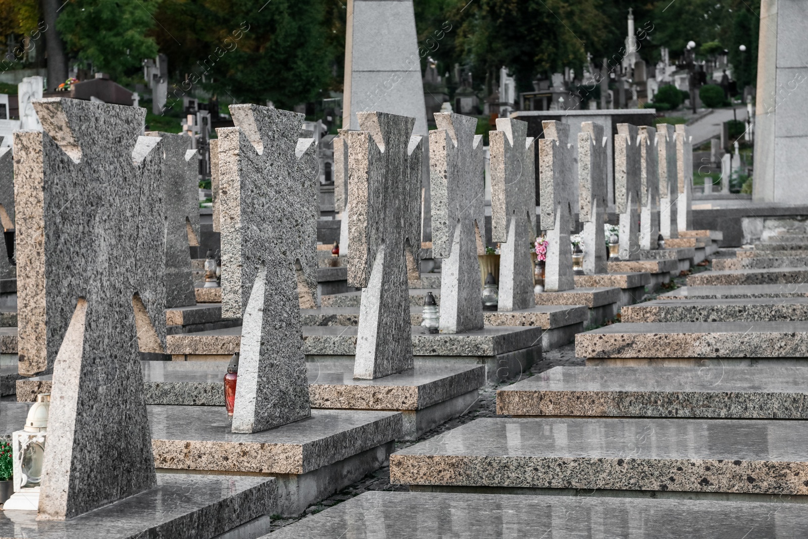 Photo of Many granite tombstones on cemetery. Funeral ceremony