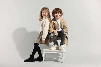 Fashion concept. Stylish children posing on light grey background