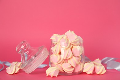 Photo of Glass jar with tasty marshmallows on bright pink background