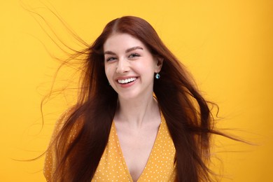 Photo of Portrait of smiling woman on yellow background