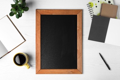 Photo of Clean small chalkboard, coffee, plant and stationery on white wooden table, flat lay