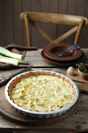 Tasty leek pie and products on old wooden table