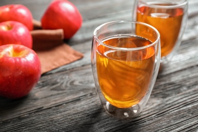 Glass of apple juice on dark wooden table