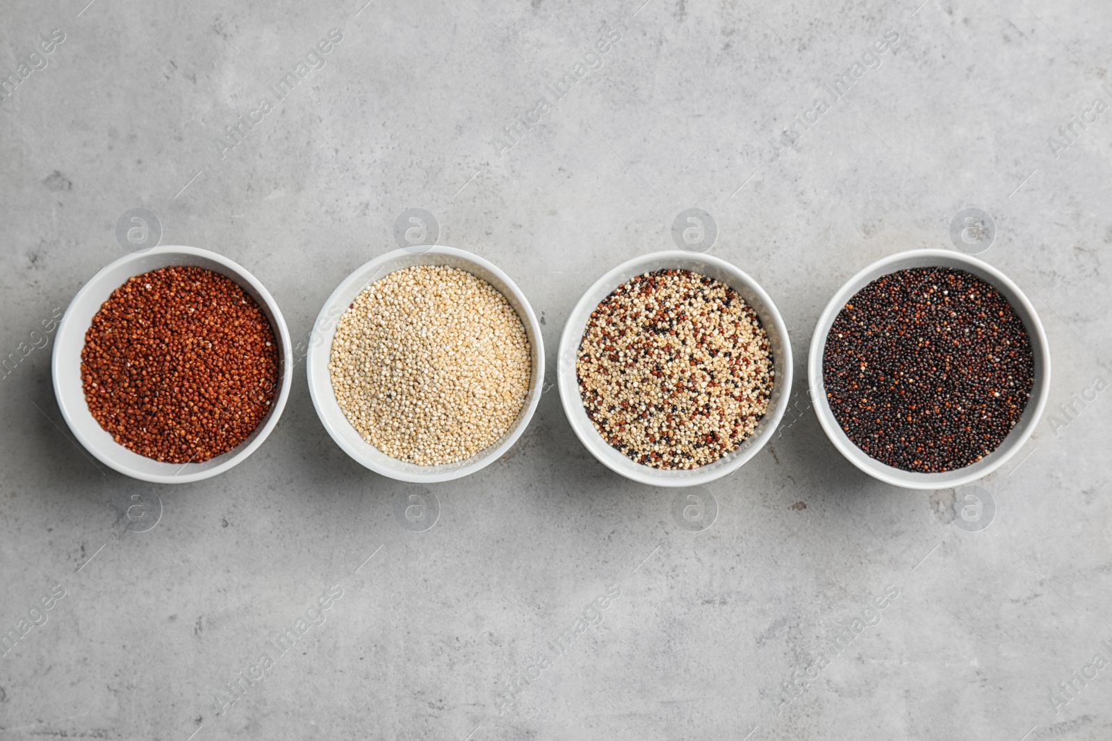 Photo of Flat lay composition with different types of quinoa on grey background