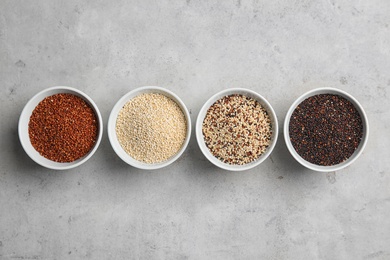 Flat lay composition with different types of quinoa on grey background