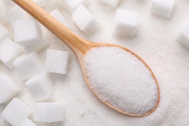 Photo of Different types of white sugar and spoon as background, top view