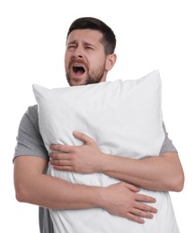 Sleepy man with pillow yawning on white background. Insomnia problem