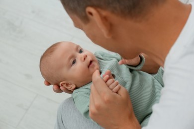 Photo of Father holding his cute baby indoors, above view