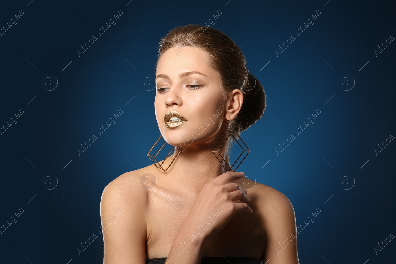 Photo of Portrait of beautiful lady with gold lipstick on color background