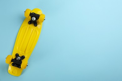 Skateboard on turquoise background, top view. Space for text