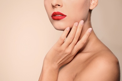 Beautiful young woman with red lips on color background, closeup