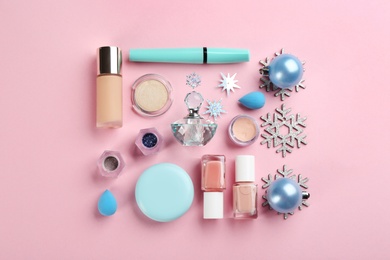 Flat lay composition with decorative cosmetic products on pink background. Winter care