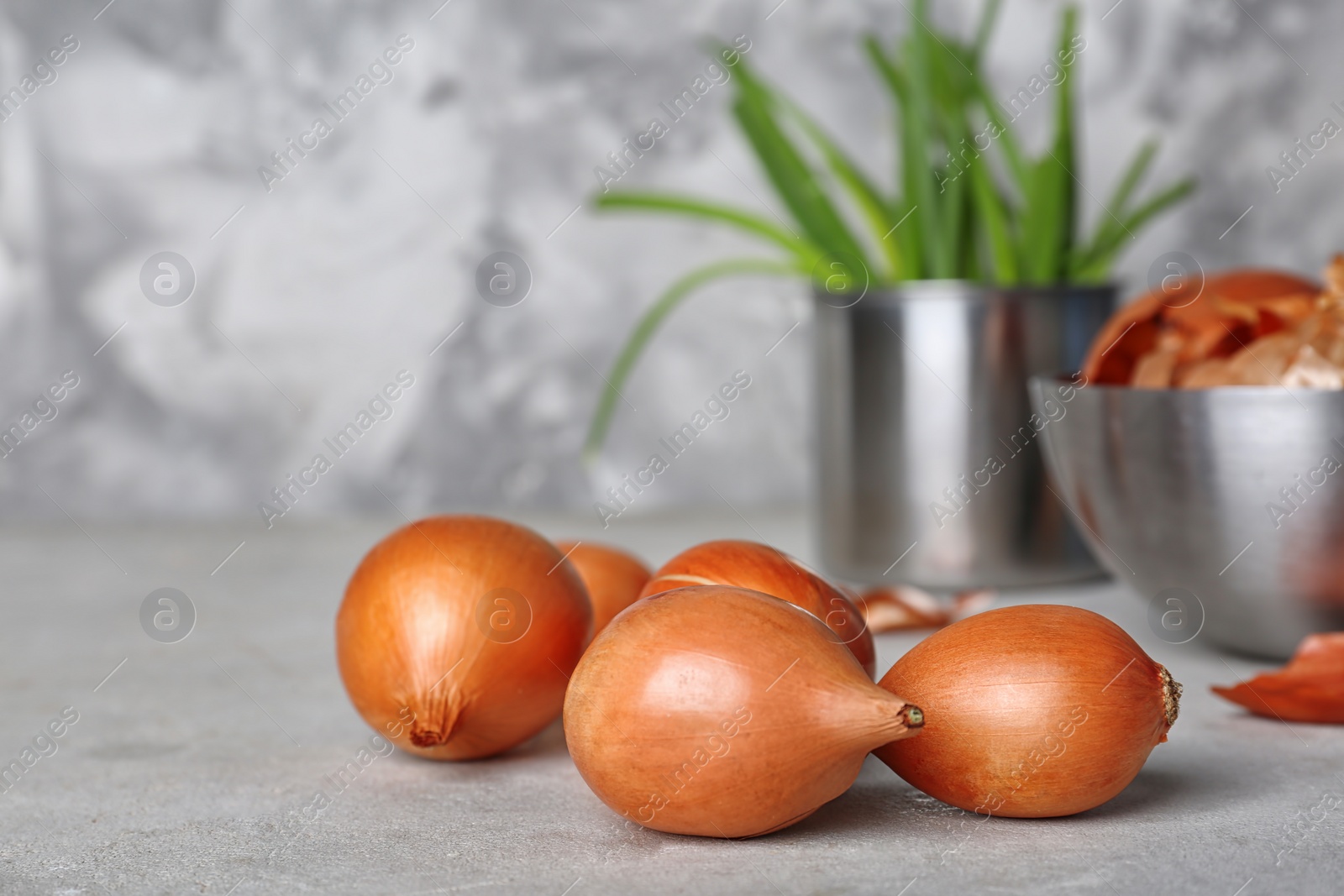 Photo of Fresh ripe onions on table against grey background