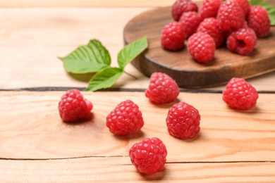 Ripe aromatic raspberries on wooden table