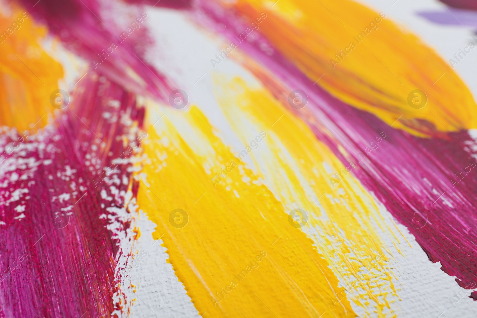 Photo of Strokes of colorful oil paints on white canvas, closeup