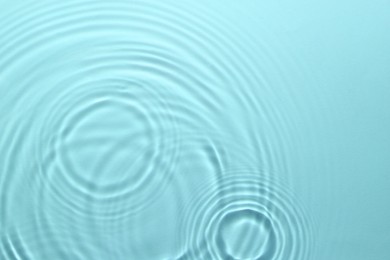 Image of Rippled surface of clear water on light blue background, top view