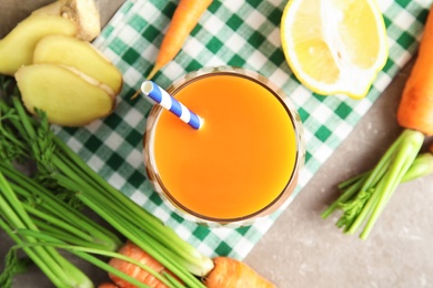 Photo of Glass with carrot juice and fresh ingredients on table, top view