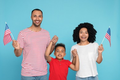 Photo of 4th of July - Independence Day of USA. Happy family with American flags on light blue background