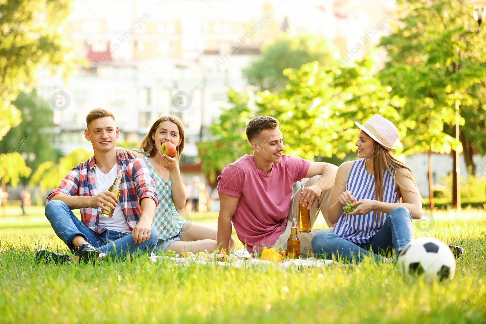 Photo of Young people enjoying picnic in park on summer day