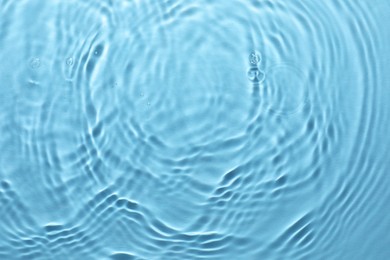 Rippled surface of clear water on light blue background, top view