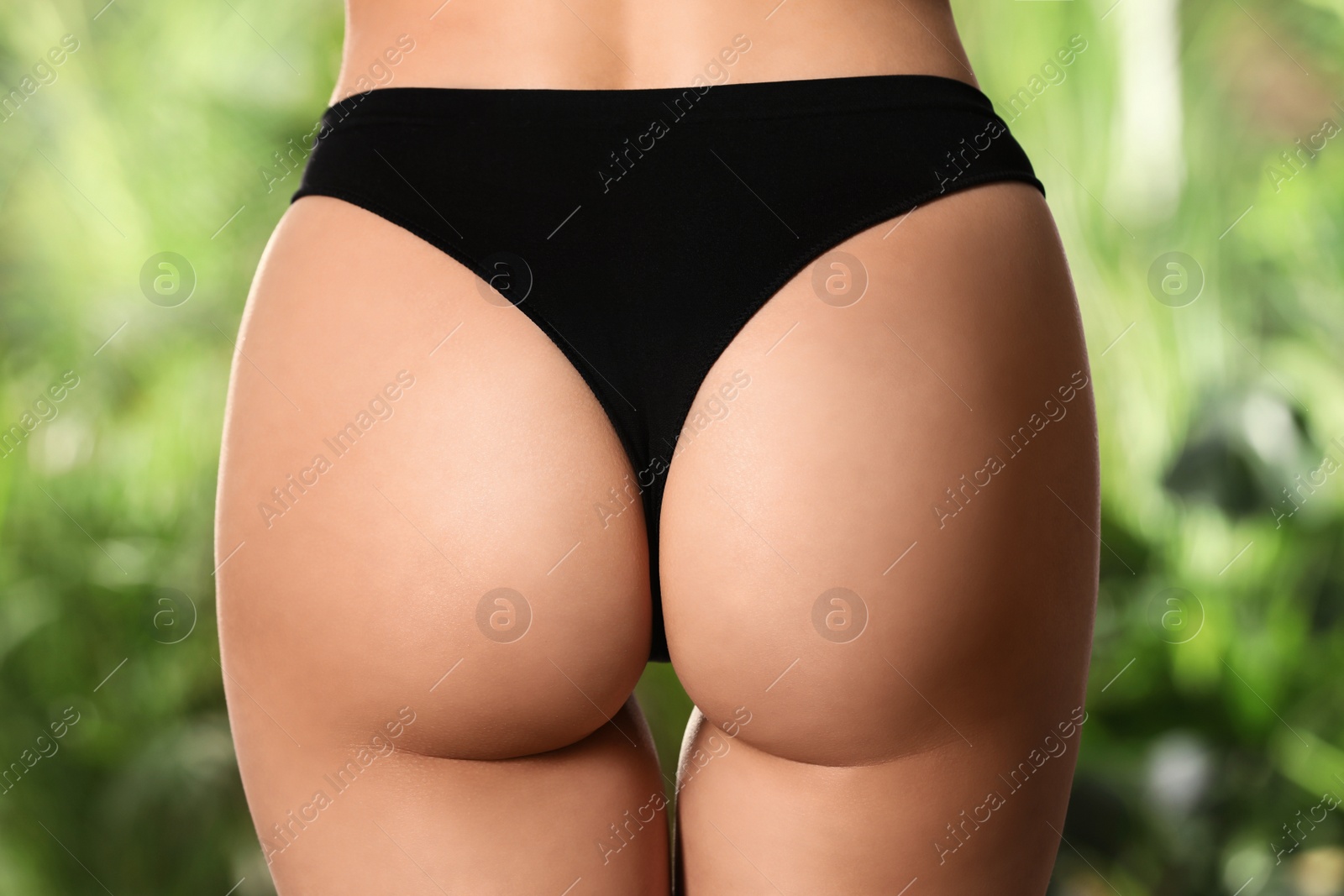 Photo of Closeup view of slim woman in underwear on blurred green background. Cellulite problem concept