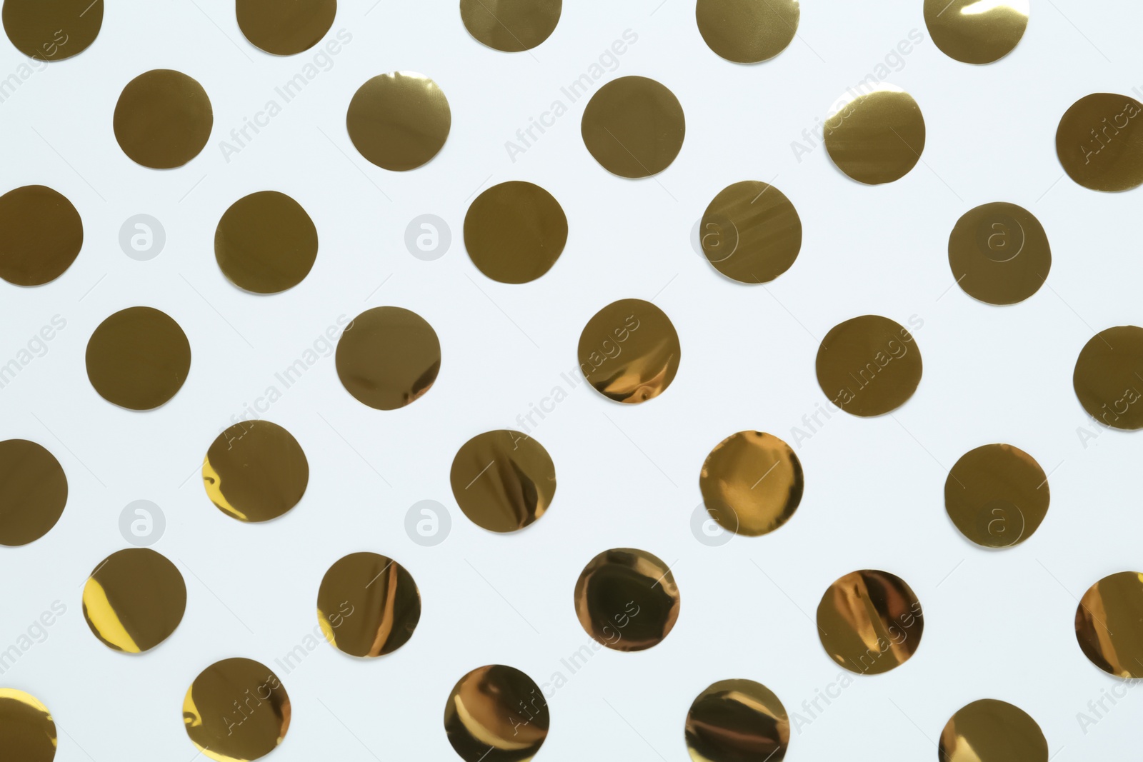 Photo of Shiny golden confetti on white background, flat lay