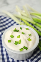 Photo of Fresh sour cream with onion on fabric, closeup